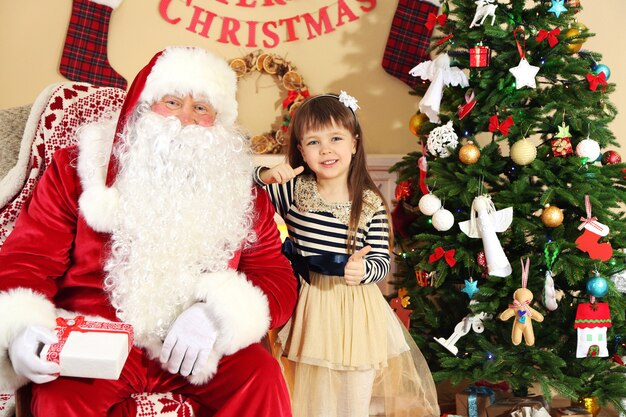 Babbo Natale che fa un regalo all'albero di Natale della bambina addormentata a casa