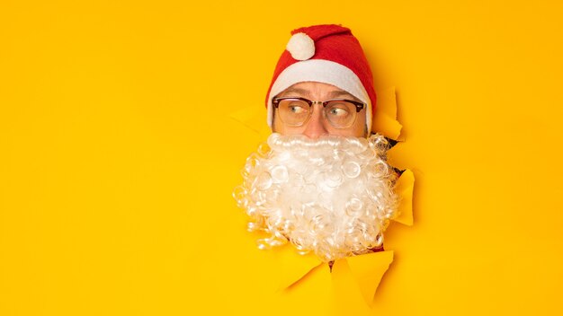 Babbo Natale che guarda attraverso il buco della carta Uomo con cappello da Babbo Natale Vacanze invernali