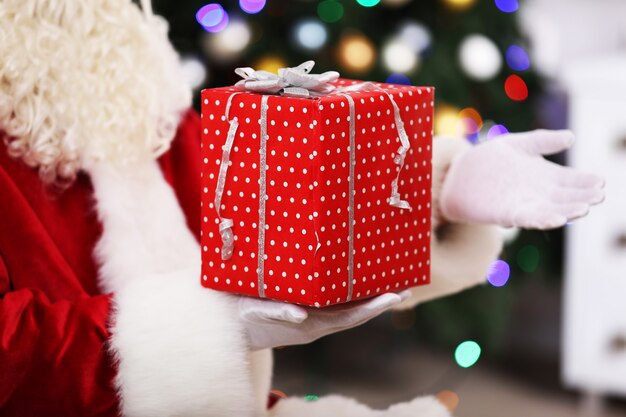 Babbo Natale che tiene il regalo sulla superficie dell'albero di Natale