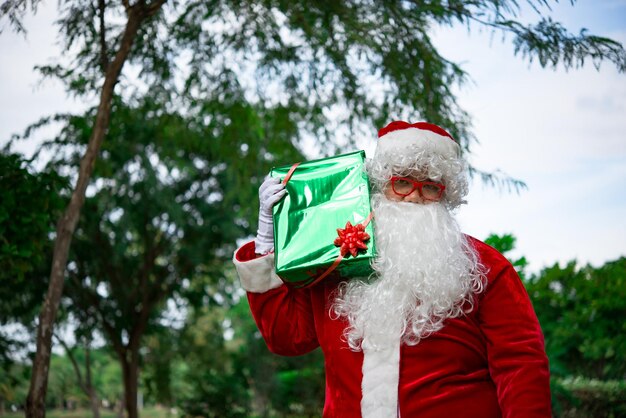 Babbo Natale con confezione regalo nella forestaLa gente della Thailandia ha inviato la felicità per i bambiniBuon NataleBenvenuto in inverno