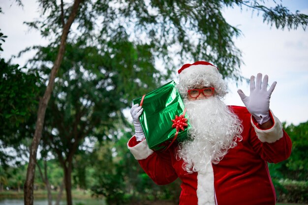 Babbo Natale con confezione regalo nella forestaLa gente della Thailandia ha inviato la felicità per i bambiniBuon NataleBenvenuto in inverno