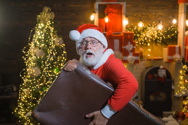 Babbo Natale con custodia da viaggio. Capodanno. Natale. Vacanze invernali. Babbo Natale. Sfondo di Natale. Babbo Natale. Buon Natale e Felice Anno nuovo. Regalo di Natale.