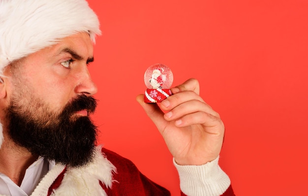 Babbo natale con globo di neve di natale uomo barbuto con piccolo elemento decorativo a palla di neve