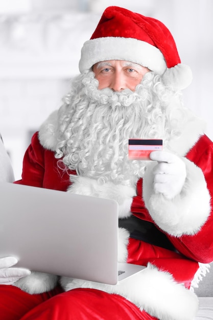 Babbo Natale con laptop e carta di credito a casa