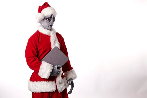 Babbo Natale con maschera aliena e tablet su sfondo bianco