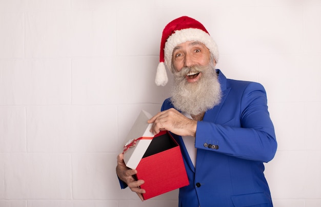 Babbo Natale con regalo di Natale. Uomo anziano barbuto in cappello rosso. Xmas. Nuovo anno.