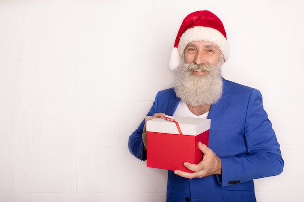 Babbo Natale con regalo di Natale. Uomo anziano barbuto in cappello rosso. Xmas. Nuovo anno.
