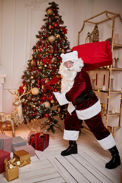 Babbo Natale con un grande sacco rosso di doni si precipita a portare il regalo ai bambini. Buon Natale, concetto di buone feste