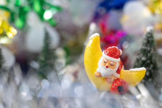 Babbo Natale dorme nella luna del croissant davanti agli alberi di Natale in attesa di una festa divertente Natale e felice anno nuovo per creare la felicità del biglietto di auguri e il concetto divertente