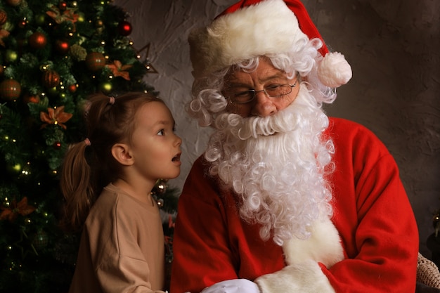 Babbo Natale e bambino a casa. Regalo di Natale. Concetto di vacanza in famiglia.