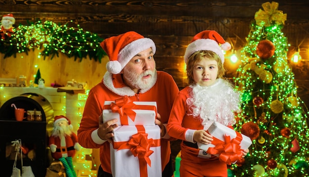 Babbo natale e bambino con regalo di natale a casa vacanze in famiglia e concetto di infanzia