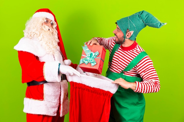 Babbo Natale e il suo amico elfo mettono i regali di Natale nella borsa per portarli ai bambini