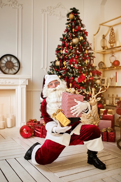 Babbo Natale felice ha portato molte scatole regalo ai bambini. Anno nuovo e concetto di vacanze di buon Natale