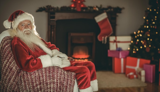 Babbo Natale festivo seduto sul divano a Natale a casa nel soggiorno