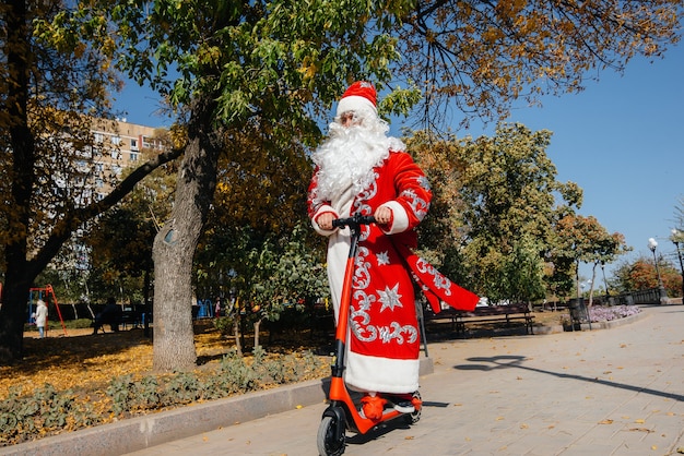 Babbo Natale ha fretta su uno scooter con regali per le vacanze ai bambini.