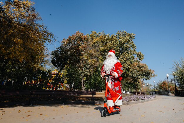 Babbo Natale ha fretta su uno scooter con regali per le vacanze ai bambini.