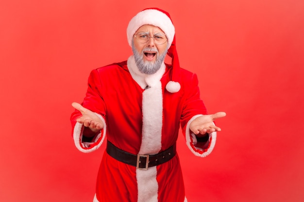 Babbo Natale in piedi con le mani alzate, espressione indignata pazza.