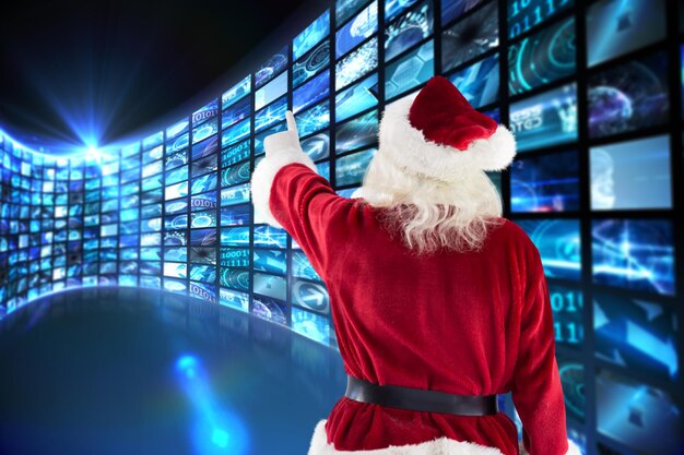 Babbo Natale indica qualcosa contro la curva degli schermi digitali in blu