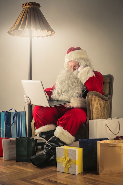 Babbo Natale lavorando sul suo computer portatile