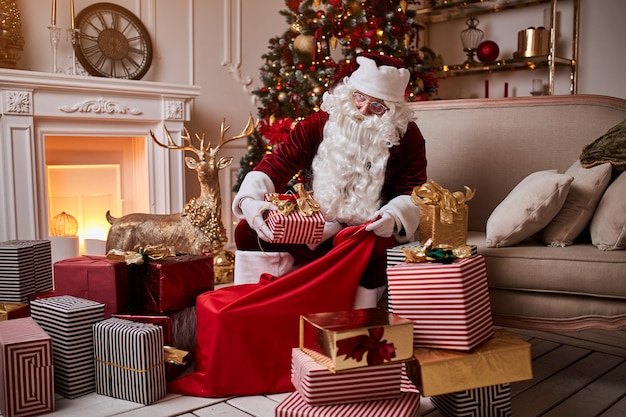 Babbo Natale mette i regali nella sua grande borsa rossa per augurare ai bambini un Buon Natale.