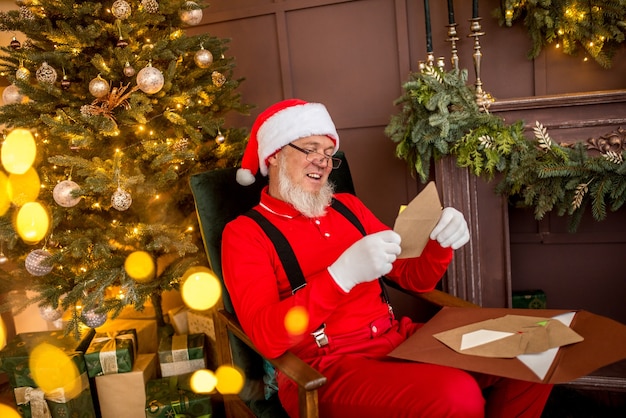 Babbo Natale moderno di lusso a casa legge una lettera