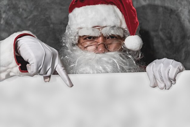 Babbo Natale punta la mano sul bordo bianco