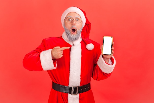 Babbo Natale scioccato che punta al display vuoto dello smartphone, mostrando un annuncio stupito.