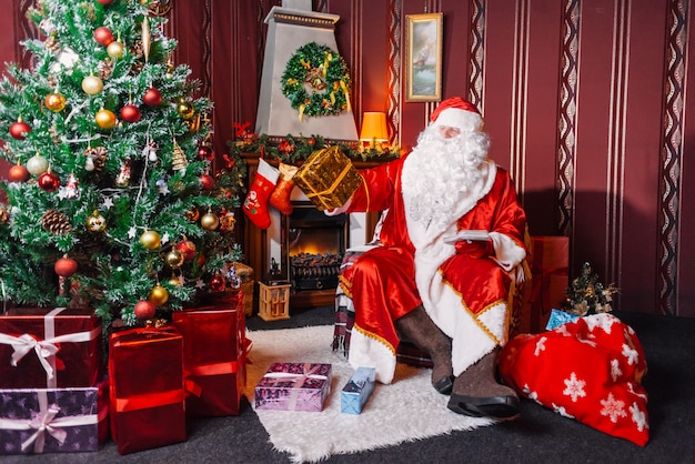 Babbo Natale seduto accanto a un albero di Natale