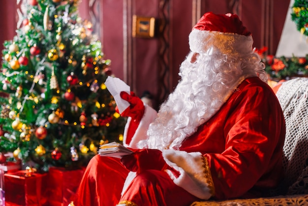 Babbo Natale seduto accanto a un albero di Natale