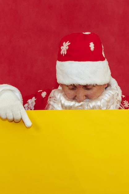 Babbo Natale si affaccia da dietro uno sfondo giallo