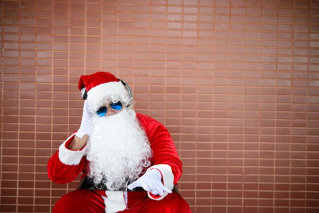 Babbo Natale si siede sulla panchina e ascolta la musicaLa gente della Thailandia ha inviato la felicità per i bambiniBuon NataleBenvenuto in inverno