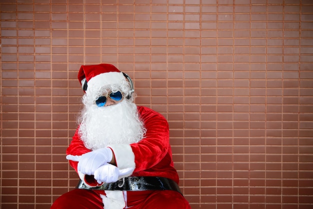 Babbo Natale si siede sulla panchina e ascolta la musicaLa gente della Thailandia ha inviato la felicità per i bambiniBuon NataleBenvenuto in inverno