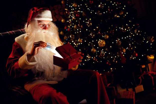 Babbo Natale sorpreso tira fuori una maschera medica da un regalo e non capisce cosa farne