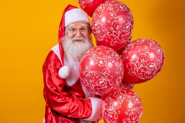 Babbo Natale su sfondo giallo con palloncini rossi.