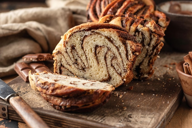 Babka al cioccolato o pane brioche Pane fatto in casa con lievito di pasta dolce al cioccolato affettato su tavola di legno rustica