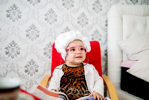 Baby in costume come una nonna seduta sulla sedia.