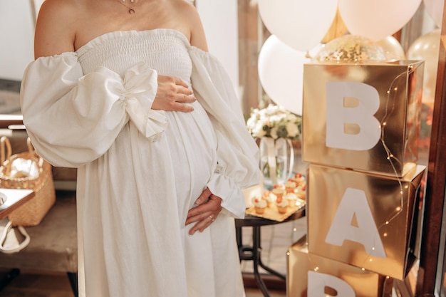 Baby shower party per amici Madre incinta che si tiene la pancia Gli amici aspettano una festa di genere Gravidanza di una giovane ragazza in una cerchia di amici