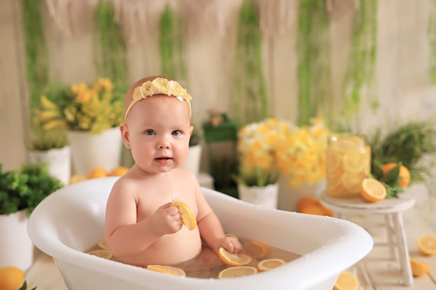 Baby sitter nella piccola vasca da bagno facendo un bagno con fette di limoni in acqua