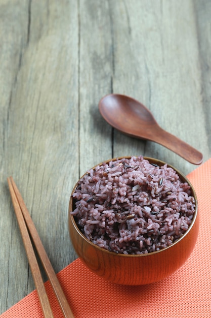 Bacca del riso organico in piatto di legno su fondo di legno.