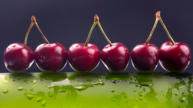 Bacca di ciliegia fresca con gocce d'acqua su una bottiglia verde. cibo sano per la colazione. frutti di vegetazione. dessert alla frutta