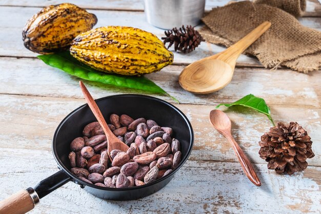 Baccelli di cacao e baccelli di cacao crudi su tavole di legno.