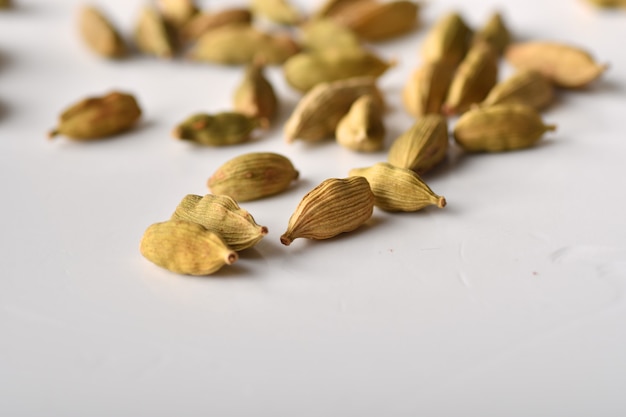 Baccelli di cardamomo verde su sfondo bianco