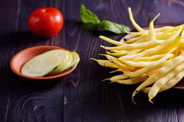 Baccelli di fagioli verdi e gialli di asparagi su un vecchio tavolo di legno rustico