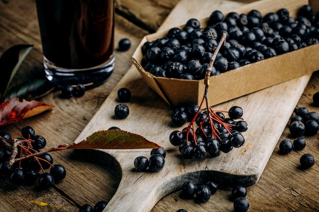 Bacche di aronia fresche e succo di bacche in un bicchiere.