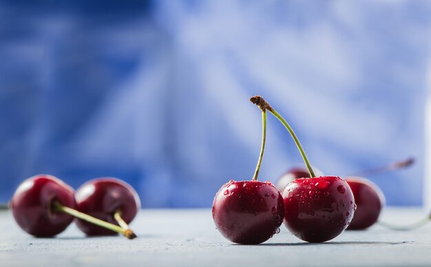 Bacche di ciliegie fresche su sfondo blu