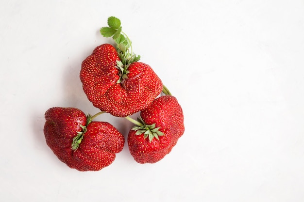 Bacche di fragole mature e divertenti Concetto di cibo alla moda Mangiare frutta e verdura brutte