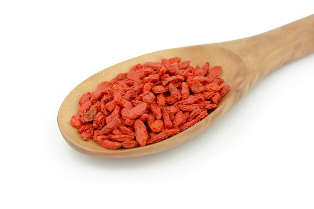 Bacche di Goji in cucchiaio di legno su sfondo bianco