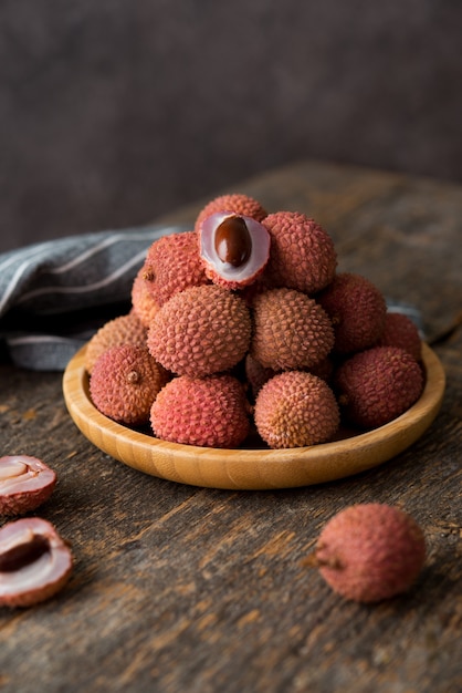 Bacche di litchi maturi in un piatto su un tavolo di legno