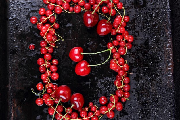 Bacche rosse con gocce d'acqua su sfondo nero Vista dall'alto Concetto di cibo sano