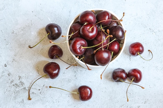 Bacche rosse mature fresche su una ciotola sullo sfondo di cemento Cibo a dieta sana